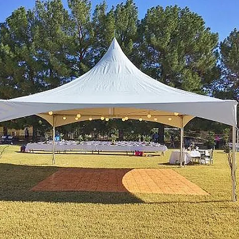 Single 20 by 20 High Peak tent with a dance floor and string lights on a lawn