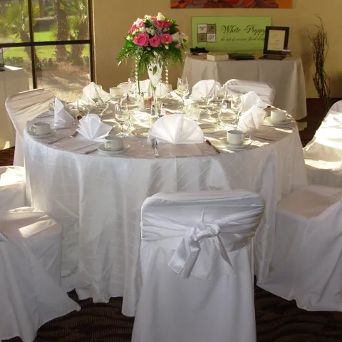 Round tables in white linens with white chair covers